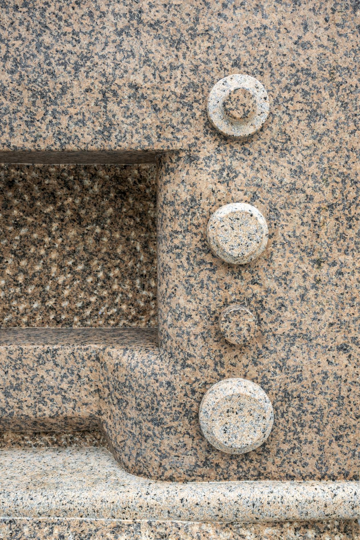 Detail knoppen naaimachine gehouwen uit roze graniet