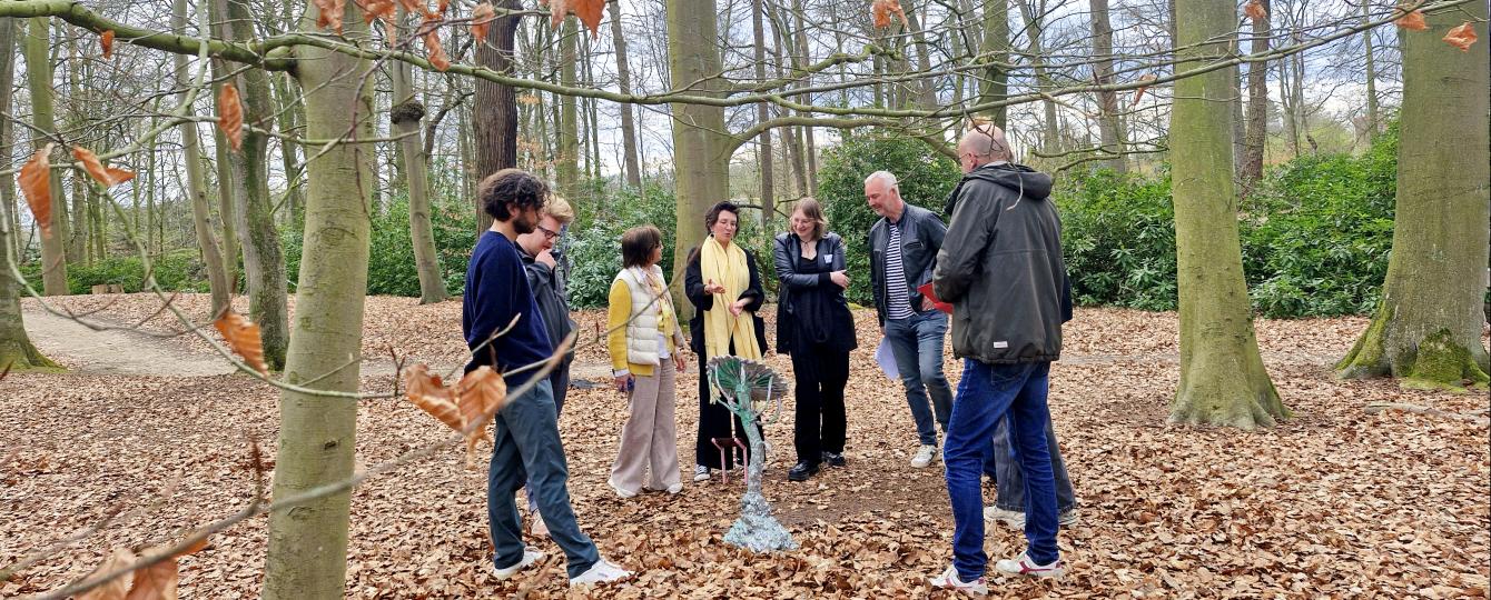 Groepje volwassenen rond het kunstwerk Artisticus Confusa in het park