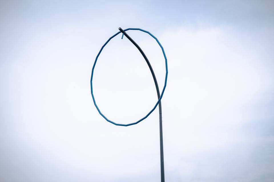 Detail kunstwerk met blauwe ring op hoge paal