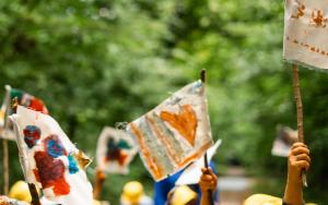 Detailzicht sfeerbeeld van kinderhanden wapperend met kleurrijke vlaggetjes 