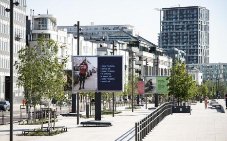 Zicht op drie grote billboards van het kunstwerk Time. And Again. van Ken Lum opgesteld aan de vernieuwde Scheldekaaien