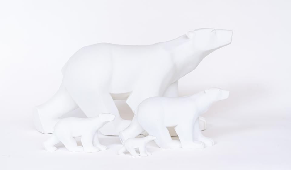 Vier kleine witte ijsbeerbeeldjes van verschillende grootte