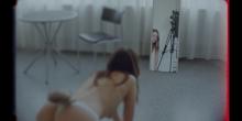Filmstill waarin een mysterieus, geslachtshybride wezen (half mens, half lynx) in een spiegel kijkt