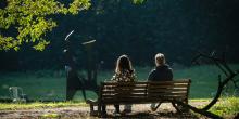 Achteraanzicht van man en vrouw op houten zitbank in het kunstpark
