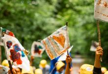 Detailzicht sfeerbeeld van kinderhanden wapperend met kleurrijke vlaggetjes 